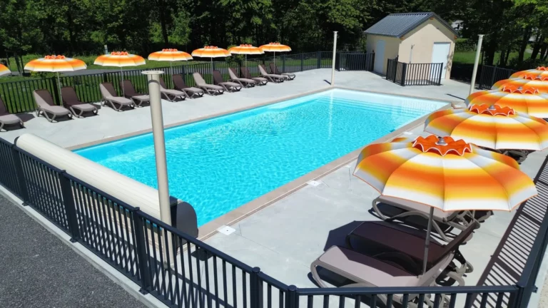 Den 6 × 15 m store pool med parasoller på Camping du Lac de Carouge