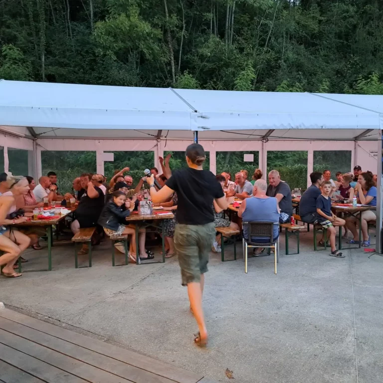 Soirée animation au camping, les campeurs réunis autour des tables